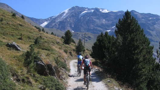 Riding mountain bikes above rifugio Forni, Italy